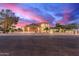 Beautiful home exterior featuring a spacious driveway, lush landscaping, and a captivating sunset backdrop at 12015 S Tuzigoot Dr, Phoenix, AZ 85044