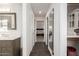 Bright hallway with dark tile floors, leading to a bedroom and featuring built-in shelves and a mirror at 12015 S Tuzigoot Dr, Phoenix, AZ 85044