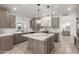 Luxurious kitchen featuring an island, custom cabinetry, marble counters, and stylish pendant lighting at 12015 S Tuzigoot Dr, Phoenix, AZ 85044