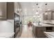 Spacious kitchen features custom cabinets, stainless steel appliances and large island with pendant lighting at 12015 S Tuzigoot Dr, Phoenix, AZ 85044