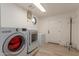 Bright laundry room with modern washer, dryer, storage, and exterior access at 12015 S Tuzigoot Dr, Phoenix, AZ 85044