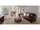 Cozy living room with a brown leather sofa, neutral rug, and seamless flow to the dining area at 12015 S Tuzigoot Dr, Phoenix, AZ 85044