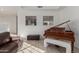 Cozy living room showcasing a grand piano, comfortable seating, and bright natural light at 12015 S Tuzigoot Dr, Phoenix, AZ 85044