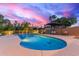 Backyard pool with mature palm trees, seating, and an umbrella at dusk at 12015 S Tuzigoot Dr, Phoenix, AZ 85044