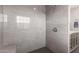 Modern shower with grey tiling, sleek fixtures, and a black tiled floor, showcasing contemporary bathroom design at 12015 S Tuzigoot Dr, Phoenix, AZ 85044
