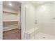 Bright bathroom featuring glass-enclosed shower with bench and adjacent walk-in closet at 12041 W Fillmore St, Avondale, AZ 85323