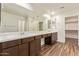 Bathroom featuring double sinks, wood cabinets, and tile floors with walk-in closet at 12041 W Fillmore St, Avondale, AZ 85323