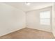 Empty carpeted bedroom with a window, baseboards, and an outlet at 12041 W Fillmore St, Avondale, AZ 85323