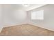 This is a bedroom with neutral carpet, white walls, and a window for natural light at 12041 W Fillmore St, Avondale, AZ 85323