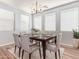 Bright dining room with modern lighting, wood floors, and a table set for six at 12041 W Fillmore St, Avondale, AZ 85323