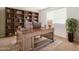 Dedicated home office with custom built-in shelving and wood desk at 12041 W Fillmore St, Avondale, AZ 85323