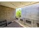 View of a covered balcony with string lights, grey brick walls, and wood plank flooring at 1225 E Medlock Dr # 206, Phoenix, AZ 85014