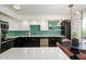 Modern kitchen boasts black and white cabinetry, stylish backsplash, stainless steel appliances, and a round dining table at 1225 E Medlock Dr # 206, Phoenix, AZ 85014