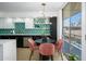 Modern kitchen featuring stainless steel appliances, black and white cabinetry, stylish light fixture, and round dining table at 1225 E Medlock Dr # 206, Phoenix, AZ 85014