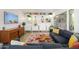Cozy living area with a large gray couch, colorful rug, and built-in shelving with plants and books at 1225 E Medlock Dr # 206, Phoenix, AZ 85014