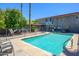 Community pool featuring clear blue water, lounge chairs, and surrounding greenery at 1225 E Medlock Dr # 206, Phoenix, AZ 85014