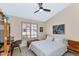 Bright bedroom offers a ceiling fan, a comfortable bed, and natural light from the window with shutters at 12730 N 90Th Way, Scottsdale, AZ 85260