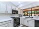 Bright kitchen features white cabinets, modern appliances, and a large window overlooking the outdoor area at 12730 N 90Th Way, Scottsdale, AZ 85260