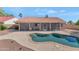 Beautiful backyard pool with a rock waterfall and a covered patio area, perfect for entertaining at 12730 N 90Th Way, Scottsdale, AZ 85260