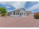 Spacious backyard with desert landscaping, a partial view of the home's rear exterior, and a storage shed at 13368 W Rimrock St, Surprise, AZ 85374