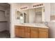 Bathroom featuring dual sinks, a large mirror, and wooden cabinets at 13368 W Rimrock St, Surprise, AZ 85374