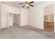 Spacious bedroom featuring carpet, ceiling fan, and entry to bathroom at 13368 W Rimrock St, Surprise, AZ 85374