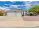 Charming single-story home boasts a three-car garage, tile roof, and neat landscaping at 13368 W Rimrock St, Surprise, AZ 85374