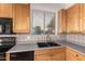 Kitchen sink with wood cabinets, grey countertops, and tile backsplash at 13368 W Rimrock St, Surprise, AZ 85374