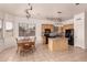 Eat-in kitchen with tile floor, center island, black appliances, and wood table at 13368 W Rimrock St, Surprise, AZ 85374