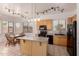 Bright eat-in kitchen with tile floor, center island, and black appliances at 13368 W Rimrock St, Surprise, AZ 85374
