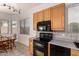 Bright kitchen with wooden cabinets, black appliances, and a tile backsplash at 13368 W Rimrock St, Surprise, AZ 85374