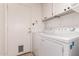Bright laundry room featuring white washer and dryer, white cabinets above, and access to the exterior at 13368 W Rimrock St, Surprise, AZ 85374