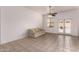 Relaxing living space with French doors leading to an outdoor area and neutral-toned tile floors at 13368 W Rimrock St, Surprise, AZ 85374