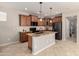 An open kitchen features wood cabinets, a black refrigerator, and a spacious island with a sink at 13602 N 149Th Ave, Surprise, AZ 85379
