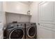 Laundry room featuring a modern front load washer and dryer with a shelf above at 13602 N 149Th Ave, Surprise, AZ 85379