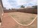 Spacious backyard is enclosed by a privacy wall, and has decorative rocks surrounding grass at 14841 W Desert Hills Dr, Surprise, AZ 85379