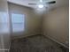 Small bedroom offers neutral paint, carpet, a window, and a ceiling fan at 14841 W Desert Hills Dr, Surprise, AZ 85379