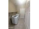 Bright laundry room features tile flooring, washer, dryer and built in shelving above appliances at 14841 W Desert Hills Dr, Surprise, AZ 85379