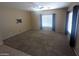 Inviting living room with large windows and neutral carpet, providing a cozy atmosphere at 14841 W Desert Hills Dr, Surprise, AZ 85379