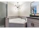 Bathroom featuring a soaking tub, modern vanity, and stylish light fixture creating a spa-like experience at 16 W Encanto Blvd # 110, Phoenix, AZ 85003
