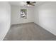 This is an empty bedroom featuring neutral paint, carpet and ceiling fan and a bright window at 18148 W Lundberg St, Surprise, AZ 85388