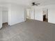 Expansive primary bedroom featuring a ceiling fan, carpet, and a connected bathroom at 18148 W Lundberg St, Surprise, AZ 85388