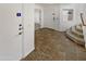 Inviting foyer with neutral-toned tile flooring, leading to various rooms, and a staircase at 18148 W Lundberg St, Surprise, AZ 85388