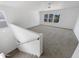 Upstairs loft features neutral carpeting, natural light, and staircase at 18148 W Lundberg St, Surprise, AZ 85388