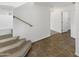 Carpeted staircase with wooden handrail leads to the upper level, complemented by neutral-toned tile flooring at 18148 W Lundberg St, Surprise, AZ 85388