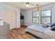 Bedroom with wood-look floors, two windows, ceiling fan, and closet at 18542 W Valerie Dr, Surprise, AZ 85374