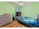 Colorful bedroom with wood-look floors, a ceiling fan, a dresser, and a tv at 18542 W Valerie Dr, Surprise, AZ 85374