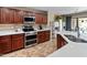 Stylish kitchen with stainless steel appliances, dark wood cabinetry, and a bright island with ample counter space at 18542 W Valerie Dr, Surprise, AZ 85374