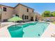Backyard oasis with a sparkling pool, green umbrella, and comfortable lounge seating, ideal for relaxation and entertaining at 18542 W Valerie Dr, Surprise, AZ 85374