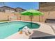 Inviting pool with green umbrella, perfect for relaxation and enjoyment in the backyard at 18542 W Valerie Dr, Surprise, AZ 85374